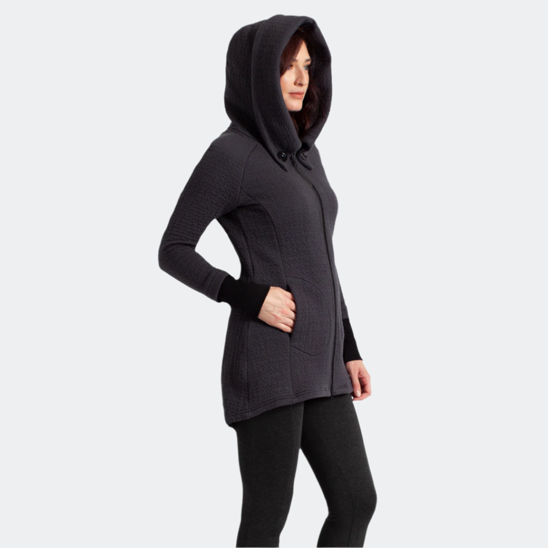 Side view of the Maggie Uniquilt Charcoal coat with the hood up, showing the pocket, rib cuffs and hi-low hem.